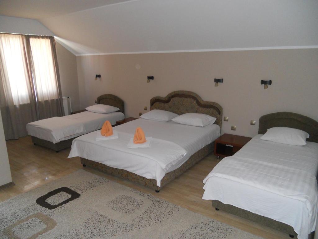 ein Schlafzimmer mit 2 Betten mit orangefarbenen Angeboten in der Unterkunft Guest house Vila Bor in Novi Sad