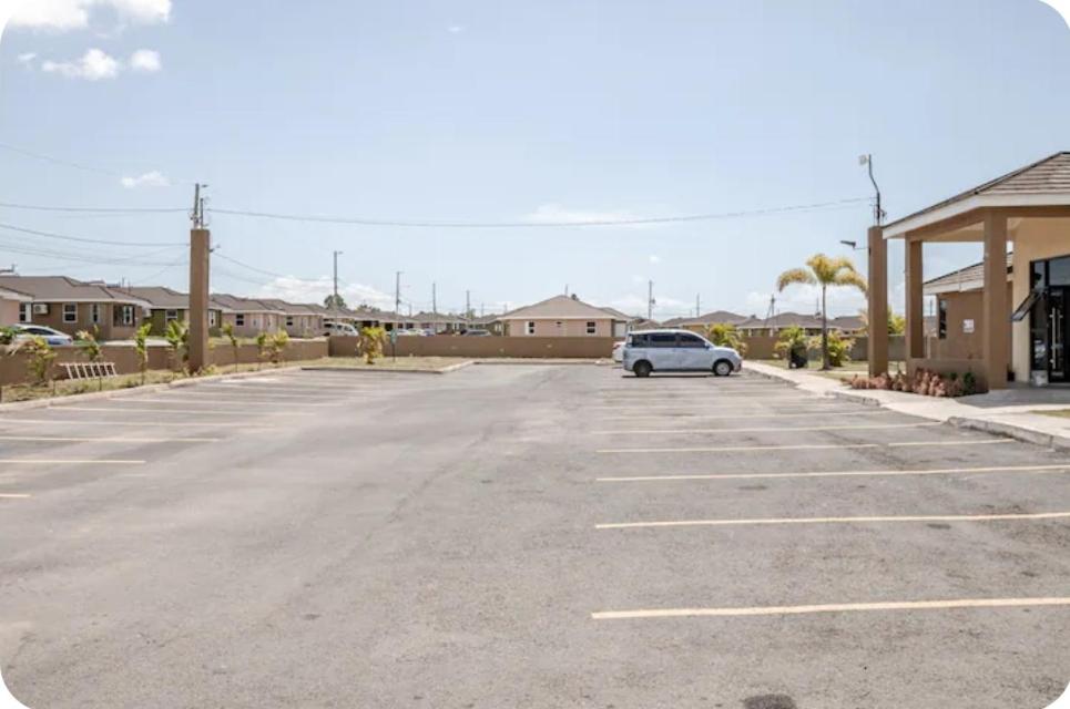 a parking lot with a car parked in it at Barefoot Bliss Short Term Rental with pool in Colbeck Manor in Claremont