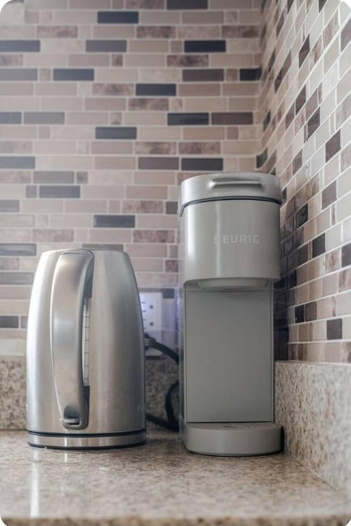 a coffee maker and a toaster sitting on a counter at Barefoot Bliss Short Term Rental with pool in Colbeck Manor in Claremont