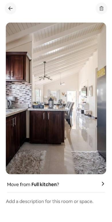 a room with a kitchen with a refrigerator and a counter at Barefoot Bliss Short Term Rental with pool in Colbeck Manor in Claremont