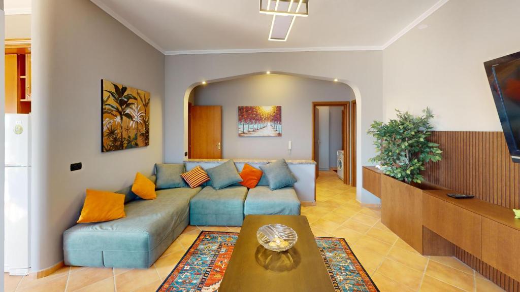 a living room with a blue couch and a table at Coastal Nest Apartments in Durrës