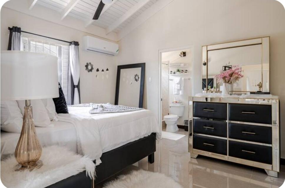 a bedroom with a large bed and a mirror at Barefoot Bliss Short Term Rental with pool in Colbeck Manor in Claremont