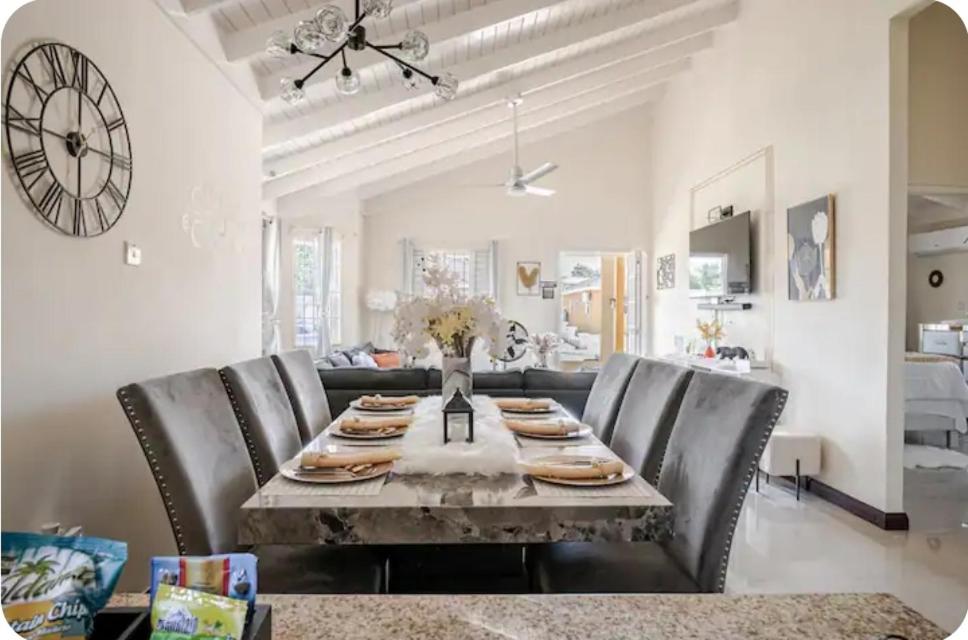 a dining room with a table and leather chairs at Barefoot Bliss Short Term Rental with pool in Colbeck Manor in Claremont