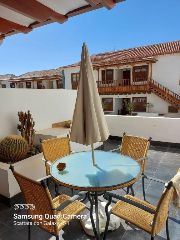 a table with an umbrella on a patio at marina in Acantilado de los Gigantes