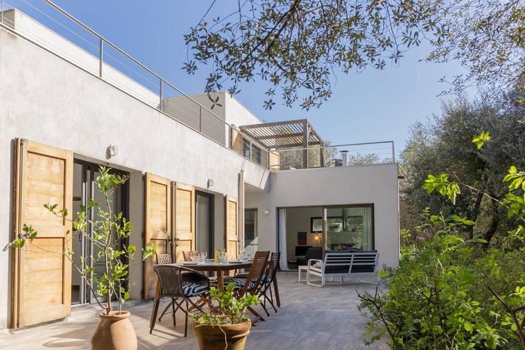 Elle offre une vue sur l'extérieur d'une maison dotée d'une terrasse. dans l'établissement Belle villa 3 chambres au cœur du maquis, à Porto-Vecchio