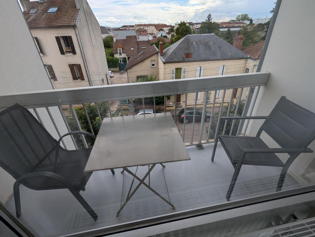 un balcon avec deux chaises et une table sur un balcon dans l'établissement Ma Bourgogne grand 3 pièces avec balcons plein sud, parking interieur, à Dijon