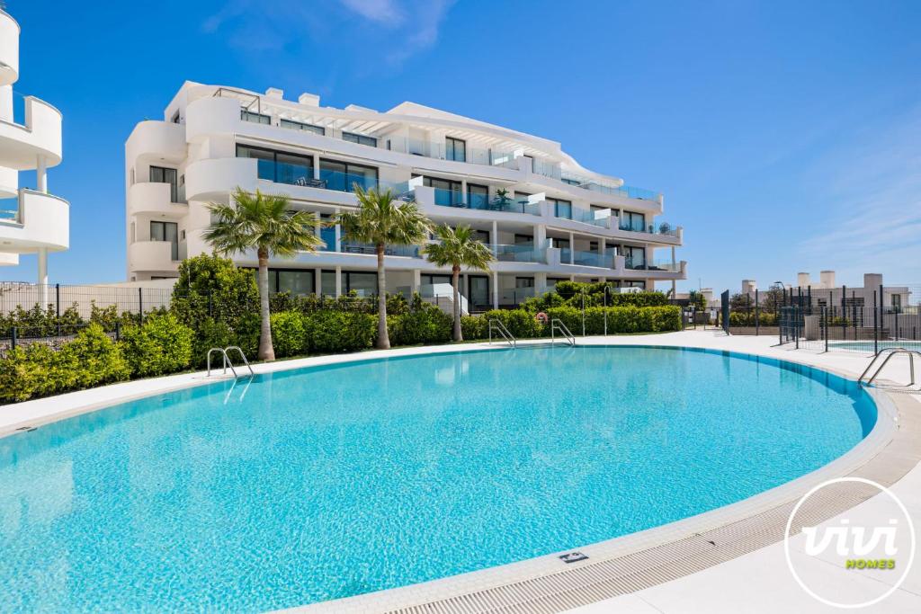 a large swimming pool in front of a building at ViVi Homes - Casa Española in Fuengirola