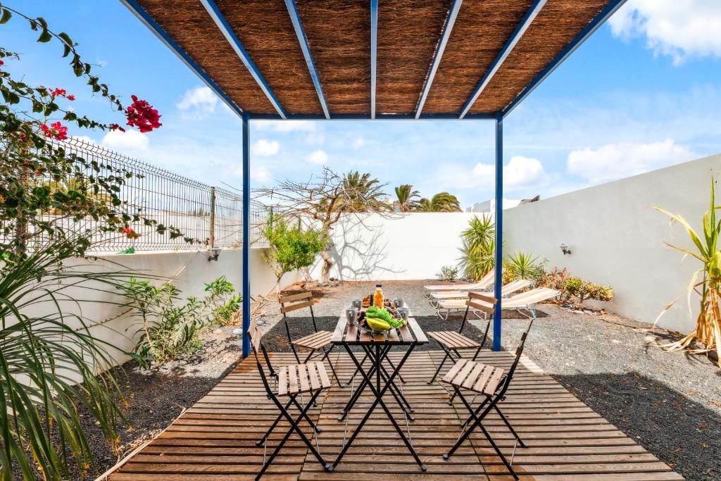 a patio with a table and chairs under a pergola at Bayside Casa Canto Refugio ideal en Costa Teguise in Costa Teguise