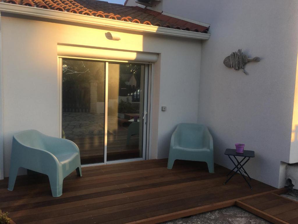 een terras met twee stoelen en een glazen schuifdeur bij Studio cosy in Frontignan