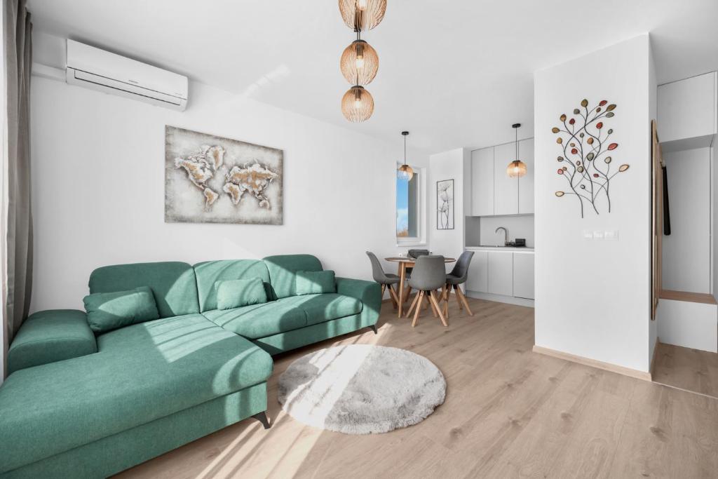 a living room with a green couch and a table at Sunny, Brand New, Luxury Apartment in Bratislava