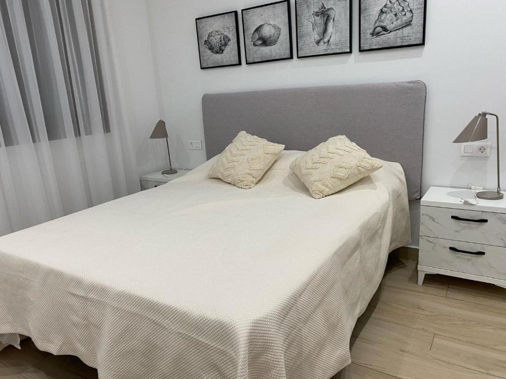 a bedroom with a white bed with two pillows on it at Condo with solarium in Laguna Beach Resort In Los Balcones in Torrevieja in Torrevieja