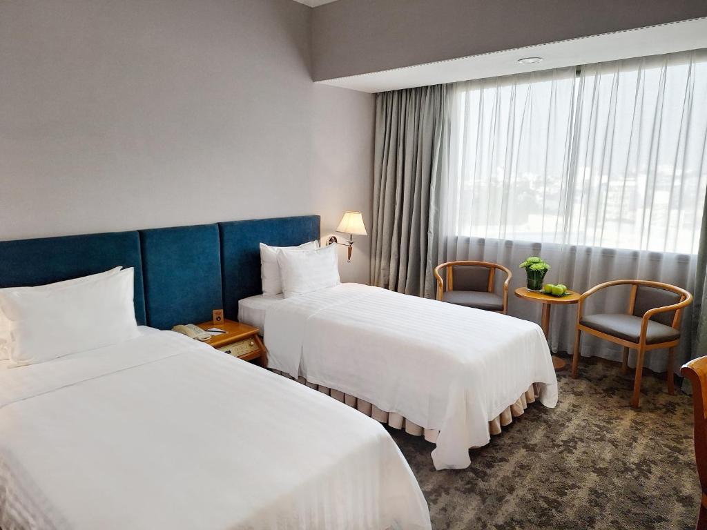 Postel nebo postele na pokoji v ubytování Hanoi Hotel