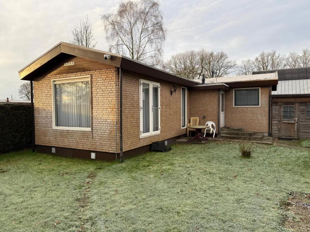 a brick house with a grass yard in front of it at Ruim Chalet Luxe 28 in Ledeacker