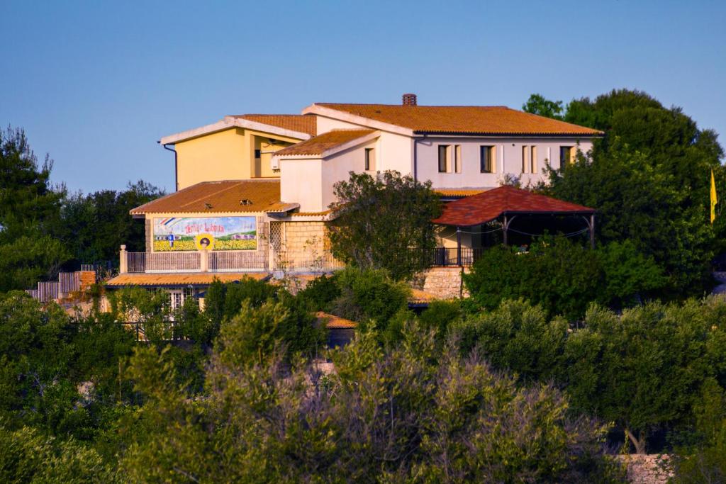 a house on top of a hill with trees at Fattoria Terra e Libertà in Contrada Maeggio