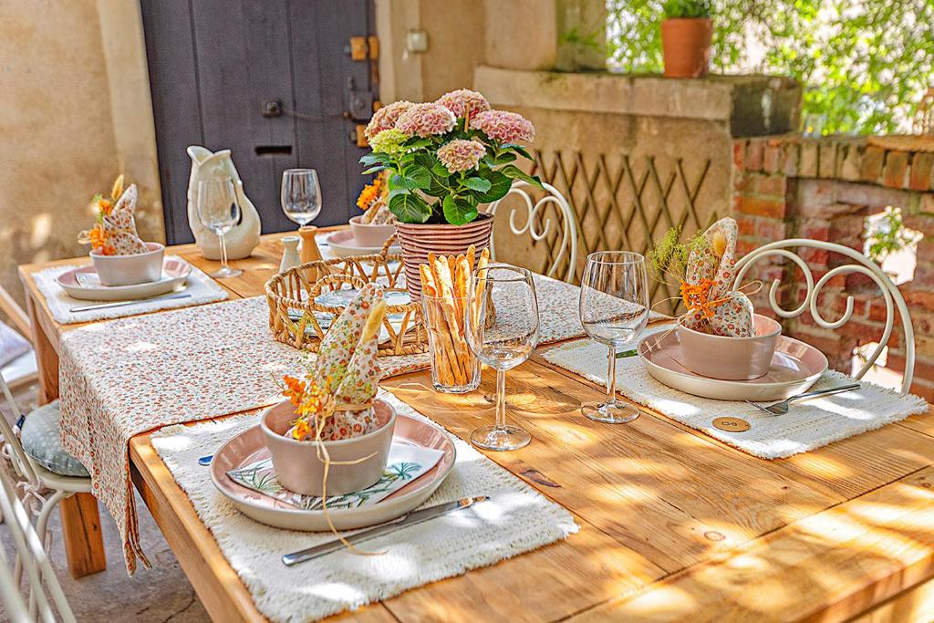- une table en bois avec des assiettes, des verres et des fleurs dans l'établissement La Terrasse Catalane, à Albi
