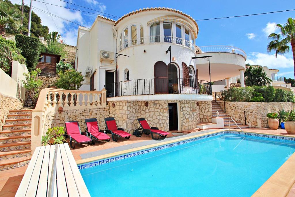 a villa with a swimming pool in front of a house at Emi - private pool & sea view villa in Benissa in Benissa
