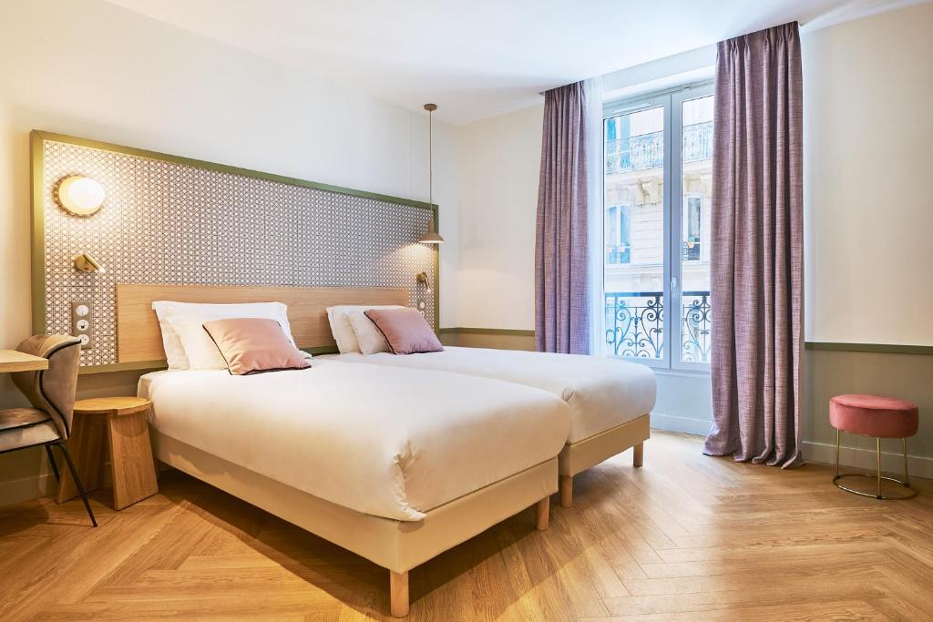 a bedroom with a large bed and a window at Hotel Cervantes by Happyculture in Paris