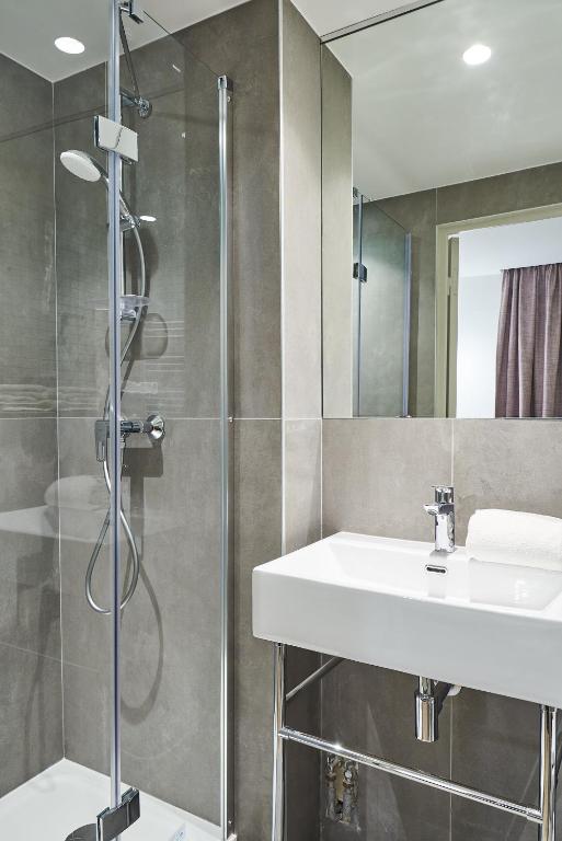 a bathroom with a sink and a shower at Hotel Cervantes by Happyculture in Paris