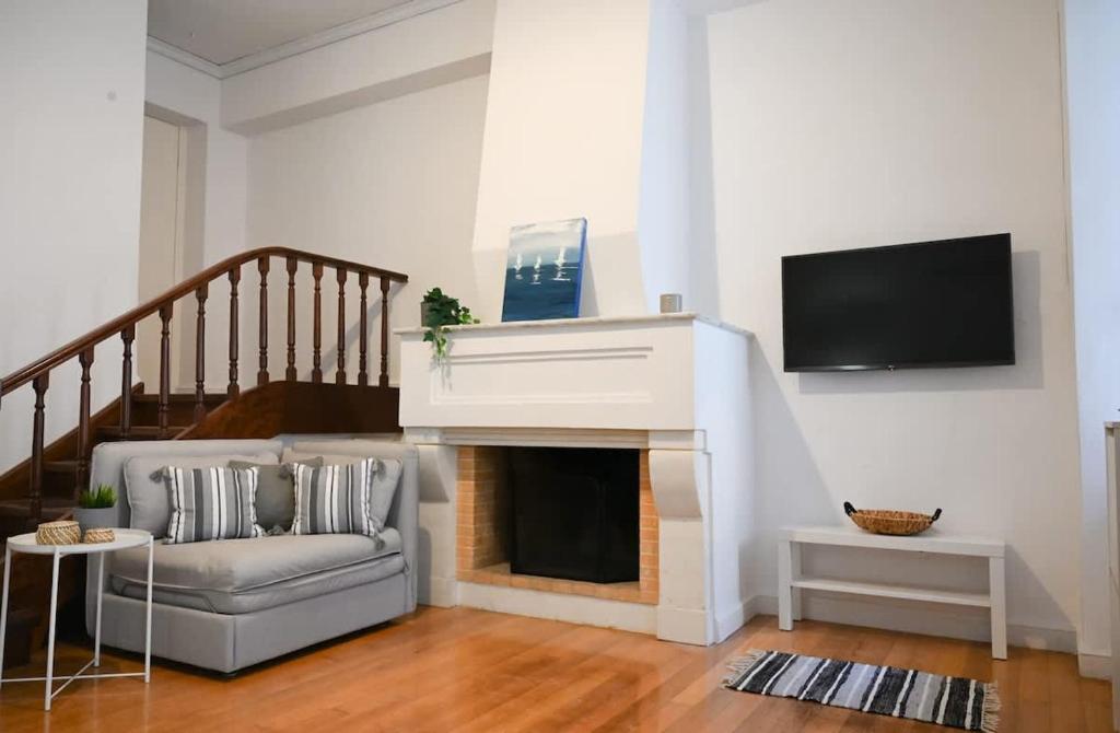 a living room with a couch and a fireplace at Hidden Gem Convenient & Spacious in Andros