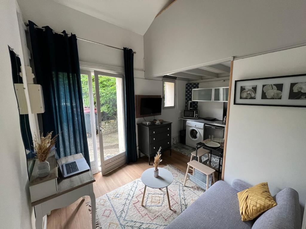 un salon avec un canapé et une table dans l'établissement Studio COSY indépendant avec MEZZANINE - CALME à Gif-sur-Yvette, à Gif-sur-Yvette