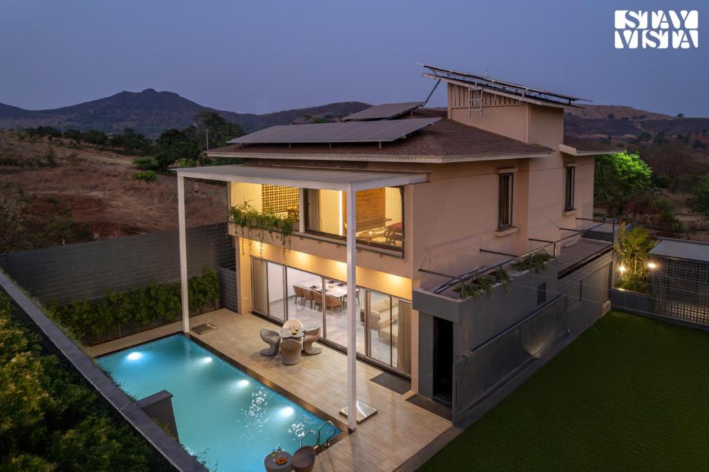 una vista aérea de una casa con piscina en StayVista at Daisy Dell with Pool, Gazebo, Wi-Fi, en Nashik