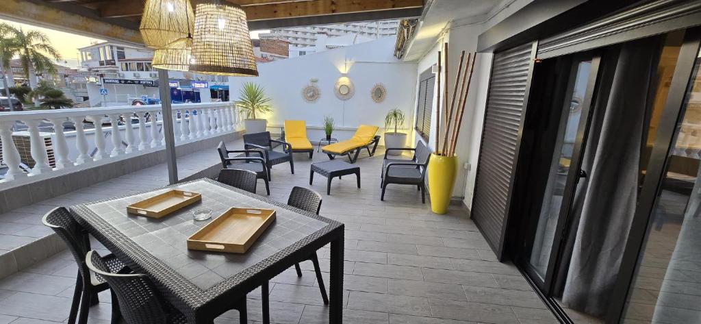 a patio with tables and chairs on a balcony at El Bungalow in Playa Fañabe