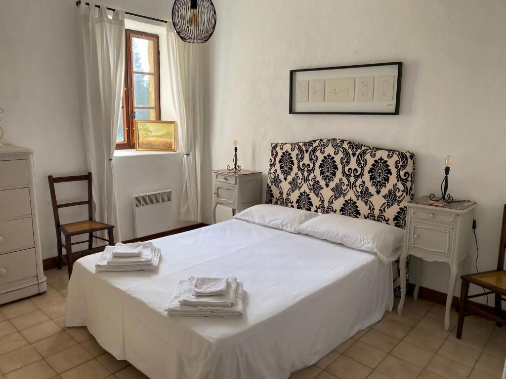 une chambre avec un lit blanc et une chaise dans l'établissement Laugerie Basse Gites - Pavot Gite, à Berbiguières