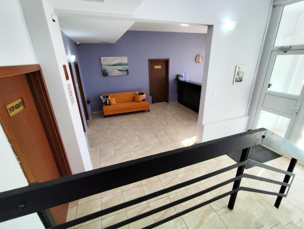 a view of a lobby with a couch and stairs at Хостел Спортна база Ветрен in Burgas City
