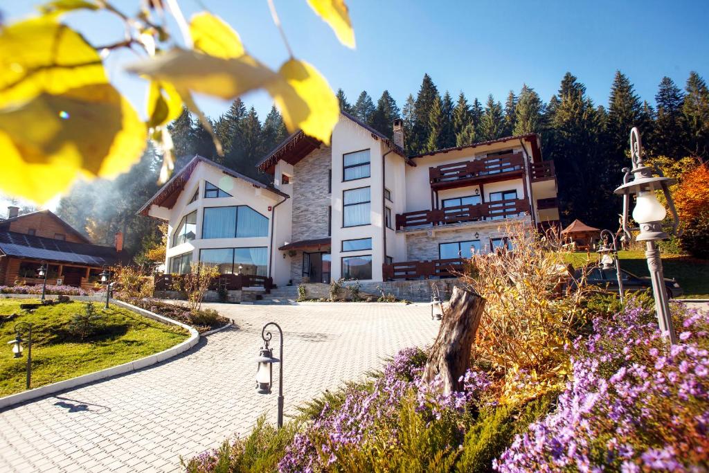 a large building with flowers in front of it at Pension Perla Bucovinei in Voronet