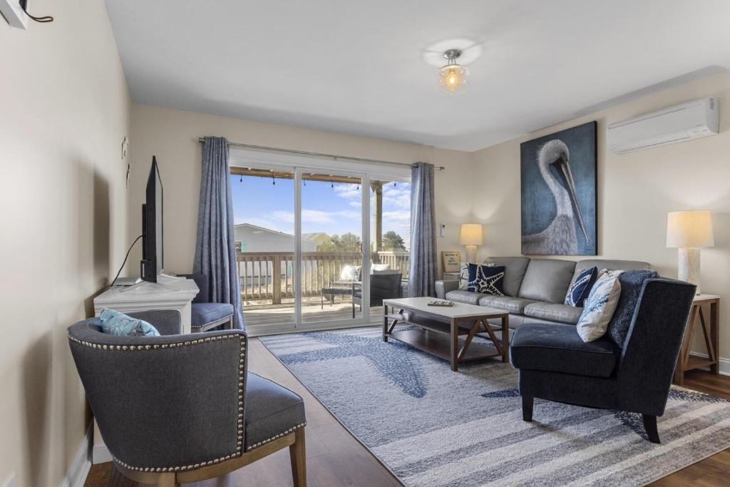 un salon avec un canapé et une table dans l'établissement The Salty Pelican townhouse, à Atlantic Beach