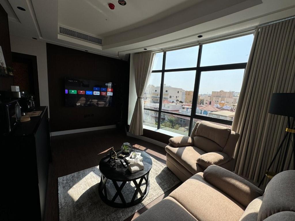 Una sala de estar con sofás y una gran ventana. en Kindah Apartment, en Yeda