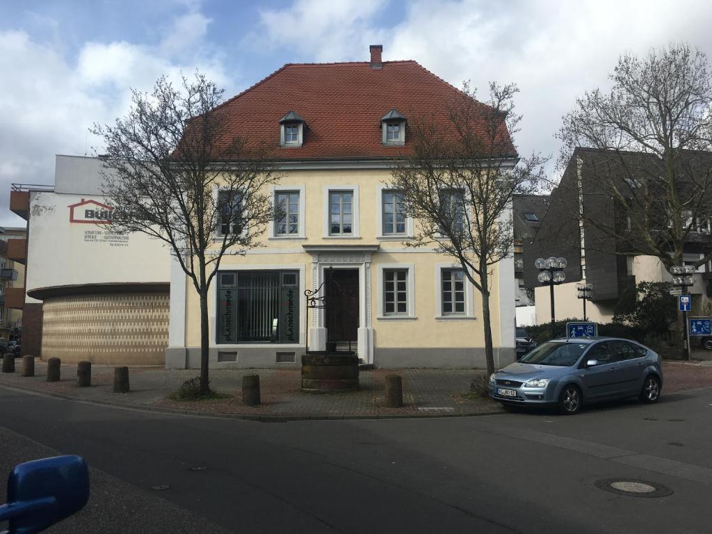 une voiture garée devant une maison blanche dans l'établissement Kaiserslautern Apartment, à Kaiserslautern