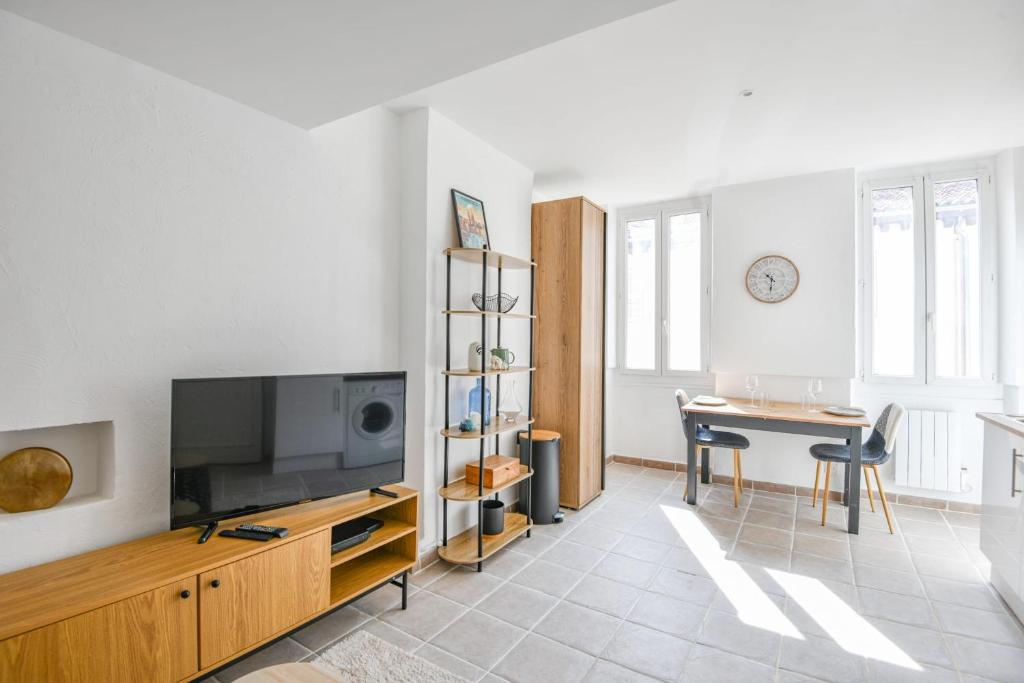un salon avec une télévision à écran plat et une table dans l'établissement Le Saens - Appart 1 ch proche Vieux-Port, à Marseille