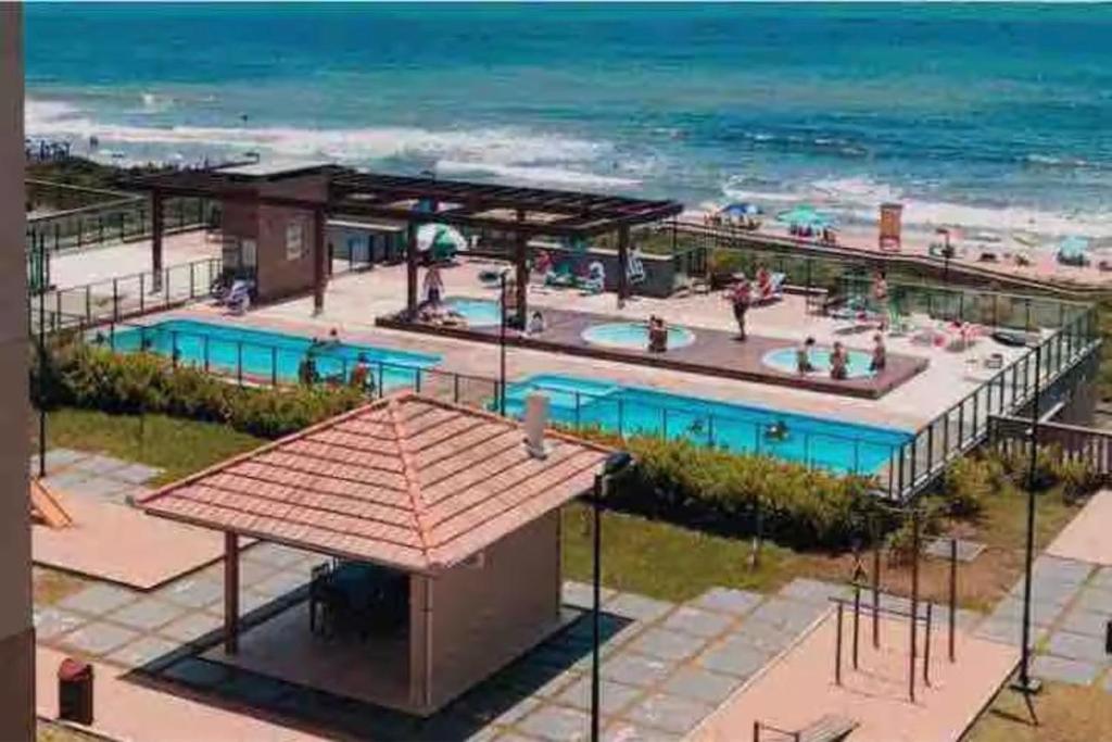 an overhead view of a swimming pool next to the beach at Apartamento Pé na Areia Barra Velha in Barra Velha