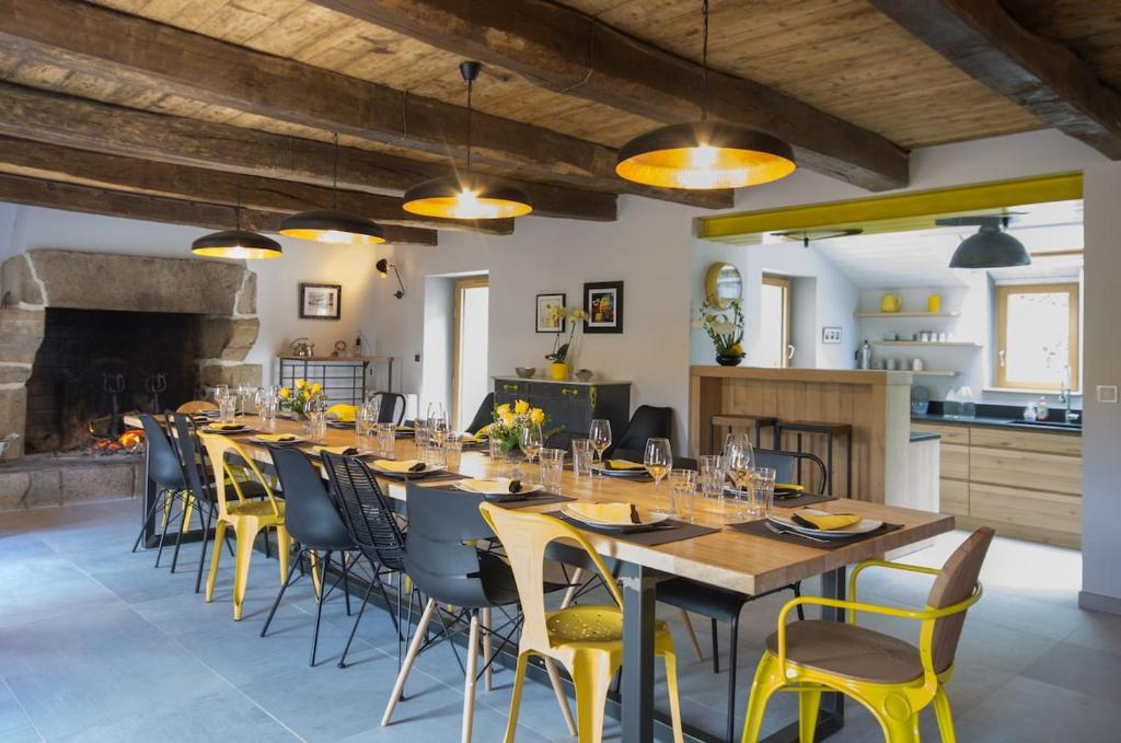 une grande salle à manger avec une longue table et des chaises dans l'établissement Le Vaugalon, Maison Grande Capacité, à Plurien
