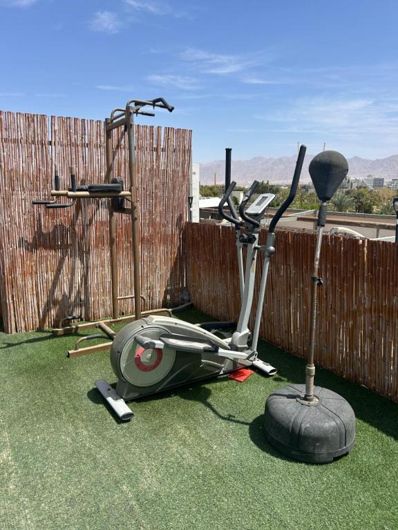 a moped parked on the grass in front of a fence at Roof top glamping and Toys suites in Eilat