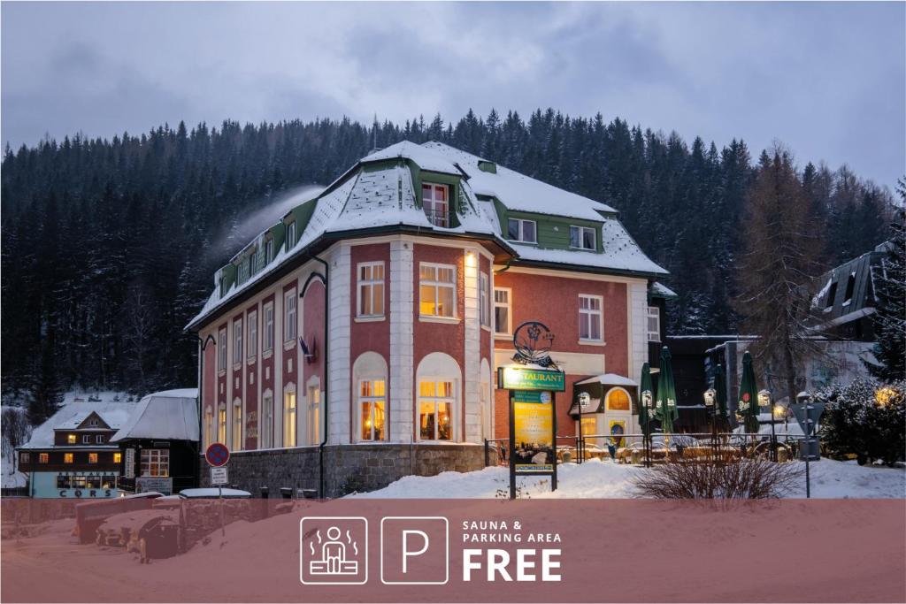ペツ・ポト・スニェシュコウにあるHotel Hořecの雪の積もった大きな建物