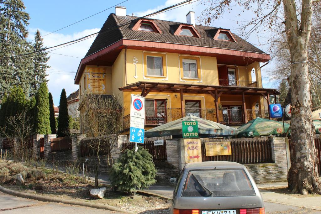 a house with a car parked in front of it at Herczeg Apartment in Miskolctapolca