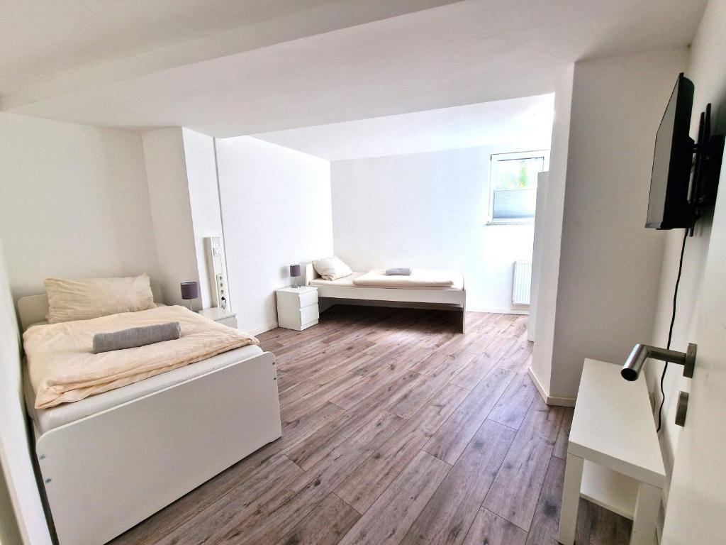 a white bedroom with a bed and a couch at BS Monteurunterkunft BE1 in Bergisch Gladbach