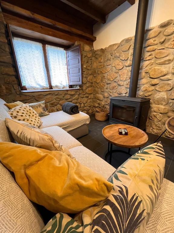 a living room with a couch and a wood stove at El Refugio de Júlia in Mier