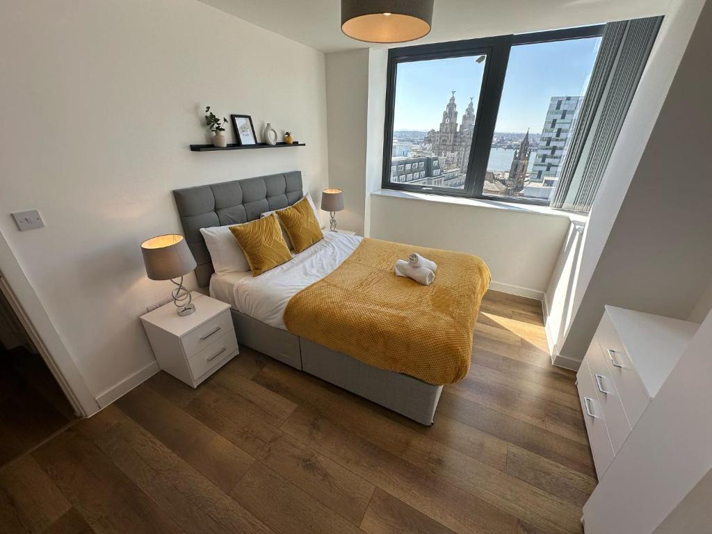 a bedroom with a bed and a large window at Two Bedroom City View Apartment Liverpool in Liverpool