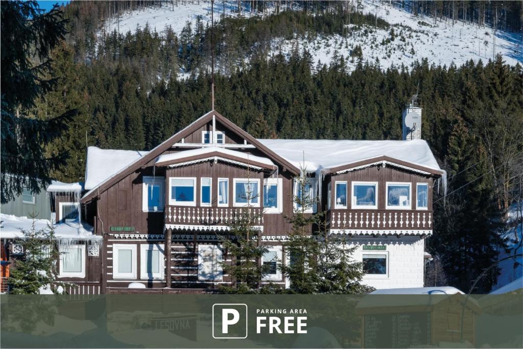 a large house with snow on top of it at CHATA LESOVNA in Pec pod Sněžkou