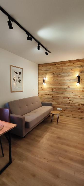 a living room with a couch and a wooden wall at Wooden Dream with Terrace in Siedlce