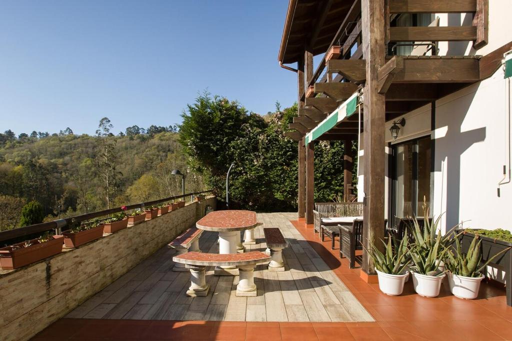 a patio with a table and benches on a building at Spacious Villa with Pool Plentzia Bilbao Area in Mendiondo