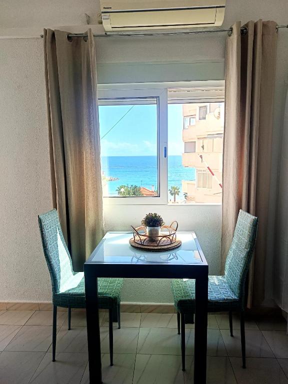 a table and chairs in a room with a window at Apartment Palasiet in Villajoyosa