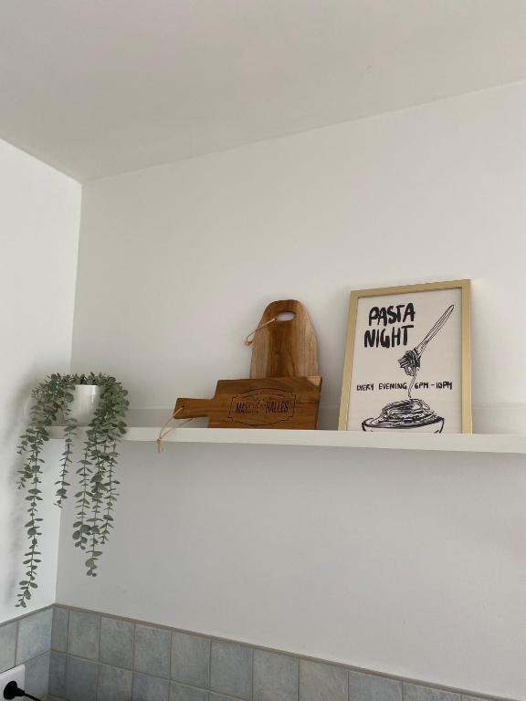 une étagère dans une cuisine avec un livre et une plante dans l'établissement Le Refuge, à Semide