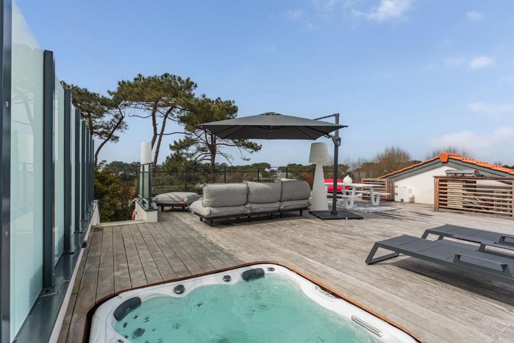 - un bain à remous sur une terrasse avec un parasol dans l'établissement Rooftop avec jacuzzi et vue dégagée haut de gamme, à Anglet