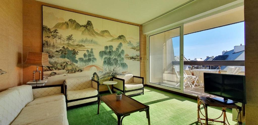 un salon avec un canapé et une grande fenêtre dans l'établissement La Terrasse Ensoleillee, à Quiberon