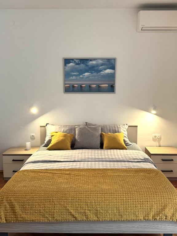 a bedroom with a large bed with yellow pillows at Rooms Kate in Krk