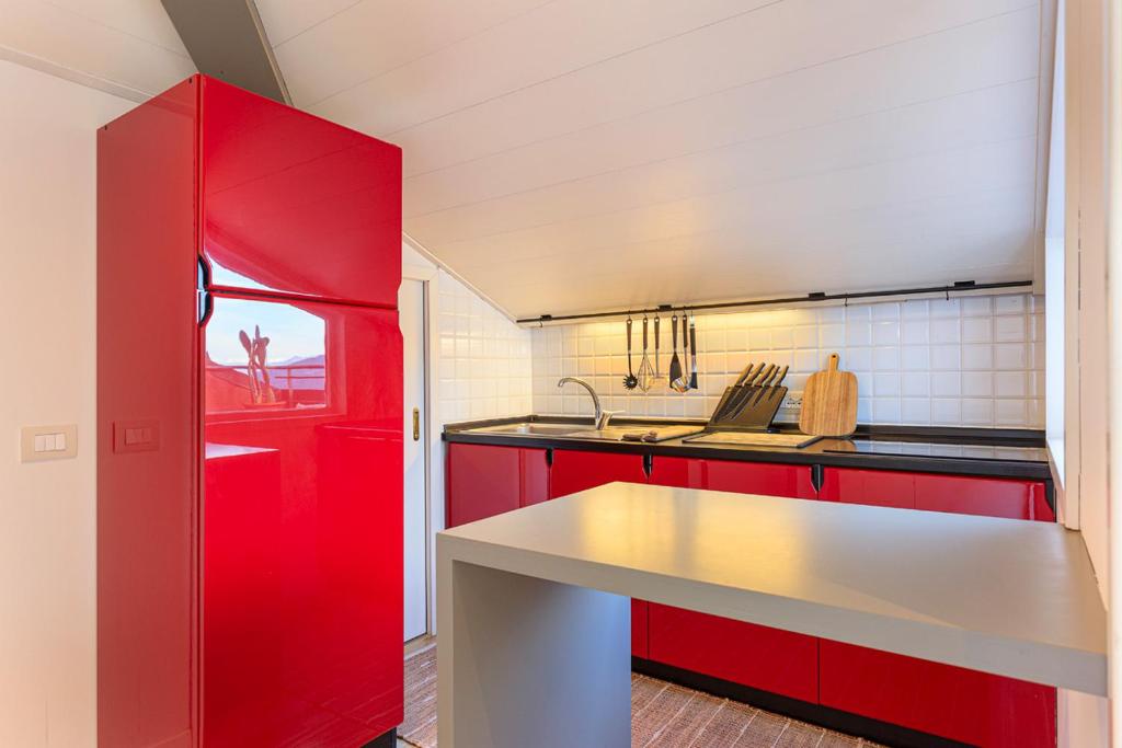 a kitchen with red cabinets and a white counter at Casa Giacomo in Arona